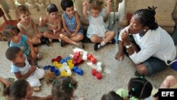 Una maestra juega con varios niños en un círculo infantil en La Habana.